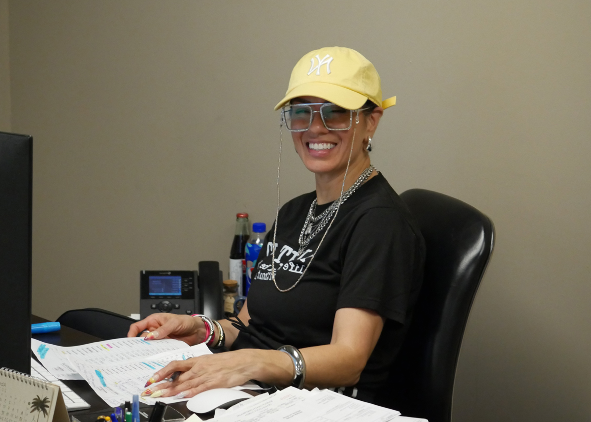 Abigail,-smiling-at-her-desk,-full-of-paperwork
